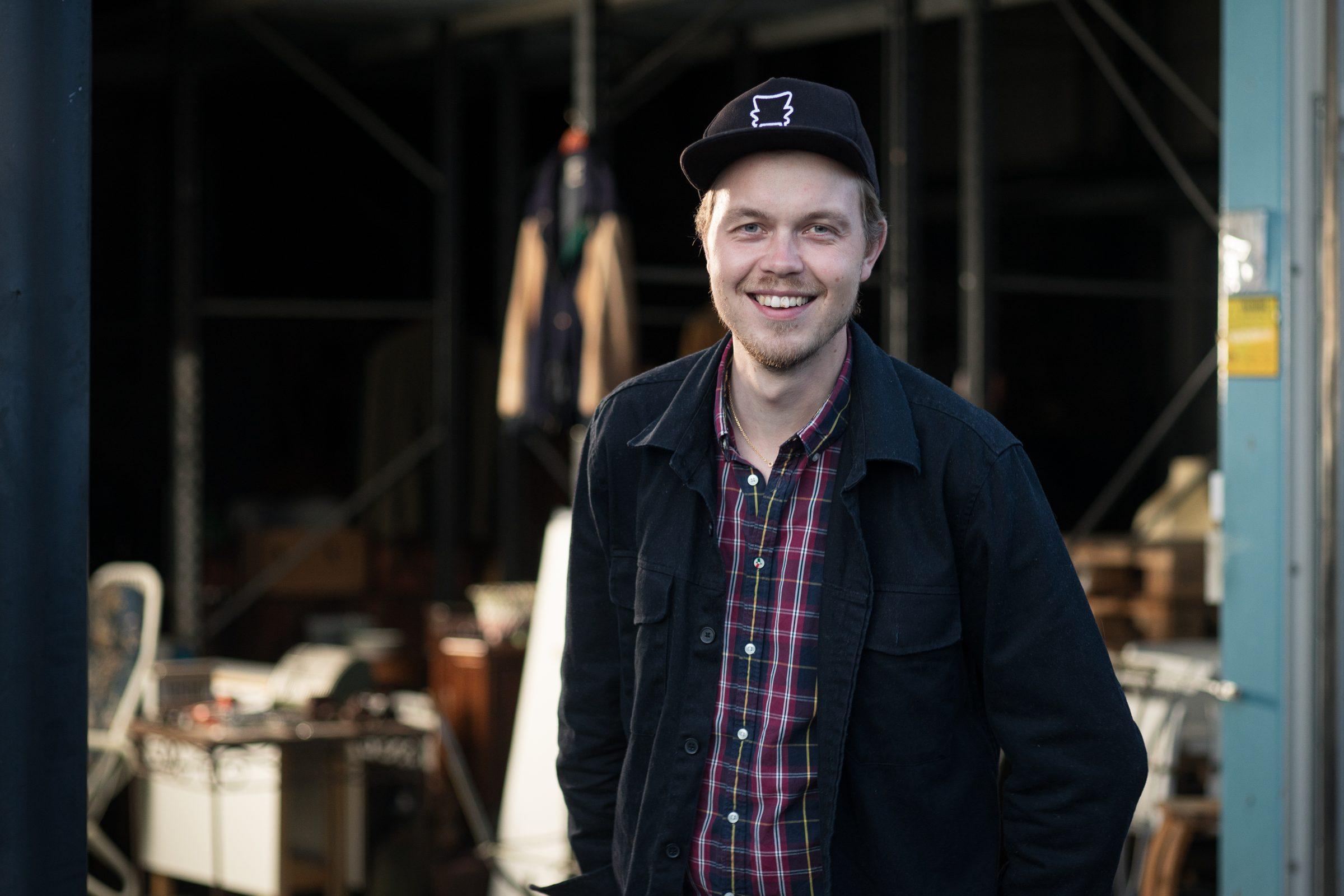 Gustav Vesterlund i keps med stolen, i lagret